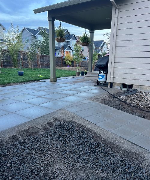 A back yard with a patio and a grill