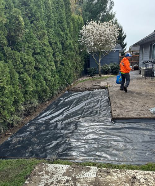 A man in an orange jacket is working on a house